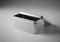 Rectangular silver tin box with an open lid, placed on a smooth gray Royalty Free Stock Photo