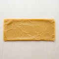 A rectangular slab of beeswax (Cera alba) sits on a light wooden Royalty Free Stock Photo
