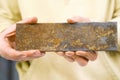 Rectangular steel piece in the hands of man. rusty iron Royalty Free Stock Photo