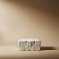 A rectangular stone block sits against a smooth, beige background Royalty Free Stock Photo