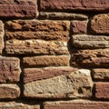 Rectangular stones of varying sizes and earthy hues form a brick wall pattern. The Royalty Free Stock Photo