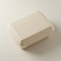 Rectangular takeaway food container made of beige cardboard. The surface appears Royalty Free Stock Photo