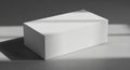 Rectangular white box positioned on a smooth gray surface with light patterns cast Royalty Free Stock Photo