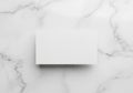 Rectangular white card placed on a smooth marble surface. The marble has a white base with subtle Royalty Free Stock Photo