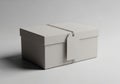 Rectangular white cardboard box with a matching lid sits on a gray surface. A thin string encircles Royalty Free Stock Photo