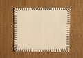 A rectangular white fabric patch is centered on a brown burlap background. The patch is bordered Royalty Free Stock Photo