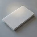 A rectangular white foam sponge lies on a smooth gray surface Royalty Free Stock Photo
