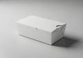 Rectangular white paper box with a folding lid, positioned on a smooth, gray background. The Royalty Free Stock Photo