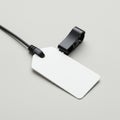 Rectangular white price tag with rounded corners attached to a black cable tie and clip Royalty Free Stock Photo