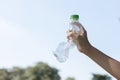 Recyclable can waste held in hand up on sky isolated background. Gyre