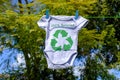 Recycle clothes icon on Babygro drying outside on washing line with 100% Recycled text Royalty Free Stock Photo