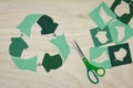 Recycle clothes symbol recycle sign cut from reuse textiles on a wooden background with scissors and cut out fabric, sustainable