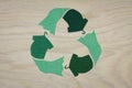 Recycle clothes symbol recycle sign cut from reuse textiles on a wooden background, sustainable fashion concept