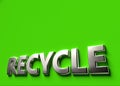 Recycle 3D sign or logo concept placed on green surface with copy space above it. New recyclable and ecological technologies