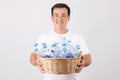 Recycle plastic concept : Portrait Asian man holding basket of empty clear old water bottle. Studio shot on grey Royalty Free Stock Photo