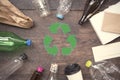 Recycle symbol and plastic, paper, glass on wood table