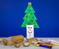 Recycle toilet roll tube, decorated and reused into Christmas tree decoration with smiling face, homemade quirky fun.