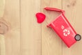 Recycle trash bin with heart on wood background