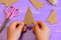 Child holds a carton Christmas tree decor in his hands. Child made Christmas decor from recycled materials. Simple crafts Royalty Free Stock Photo