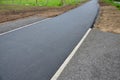 Recycled asphalt crumb is used on the edge of the new cycle path and in the subsoil of the asphalt road. between the field and the