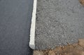 Recycled asphalt crumb is used on the edge of the new cycle path and in the subsoil of the asphalt road. between the field and the Royalty Free Stock Photo
