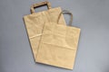 Recycled,brown,paper,shopping bag,handle, on gray background, flat lay, mockup. Two folded empty paper bag. Close-up. Selective