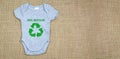 Baby grow with the future is green text on recycled fabric background. Copy space. Zero waste and sustainable