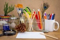 Recycled jars, tin and mug reused for different contents on wooden bench,  with blank note paper Royalty Free Stock Photo