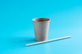 Recycled paper cup and drinking straw on blue background. Eco-friendly biodegradable drinkware. Zero waste concept
