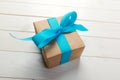 Recycled paper gift box with Blue ribbon on old wooden white background.Top view Royalty Free Stock Photo