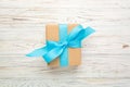 Recycled paper gift box with Blue ribbon on old wooden white background.Top view Royalty Free Stock Photo