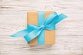 Recycled paper gift box with Blue ribbon on old wooden white background.Top view vintage, toned Royalty Free Stock Photo