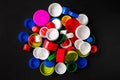 Recycled plastic bottle caps. Top view of a pile of colorful plastic bottle caps on a black background. Separate garbage Royalty Free Stock Photo