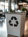 Recycling bin in a modern office setting, focus on symbol. Royalty Free Stock Photo