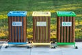 Recycling bins of different colors yellow, green, blue outdoors. Garbage bin in the park, trash can on green grass background. Royalty Free Stock Photo