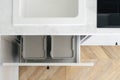 Recycling boxes over sink in white modern kitchen Royalty Free Stock Photo