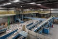 a recycling center, with bins and machines sorting and reprocessing materials