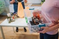 Recycling concept. Mixed electronic waste in plastic contaner close-up. Responsible woman is protecting environment