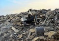 Recycling concrete and construction waste from demolition. Excavator at landfill of the disposa. Reuse of building rubble. Backhoe