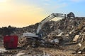 Recycling concrete and construction waste from demolition. Excavator at landfill of the disposa. Reuse of building rubble. Backhoe