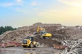 Recycling concrete and construction waste from demolition. Excavator and wheel loader at landfill of the disposa. Reuse of