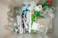 Recycling and ecology. Sorting segregating household waste paper, glass, plastic into contaner captured from above, flat lay. Royalty Free Stock Photo