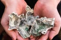 Recycling fake banknotes. Counterfeit banknotes wrinkled in hands