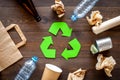 Recycling. Green recycle eco symbol. Recycled arrows sign near matherials for recycle and reuse on dark wooden Royalty Free Stock Photo