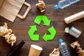 Recycling. Green recycle eco symbol. Recycled arrows sign near matherials for recycle and reuse on dark wooden Royalty Free Stock Photo