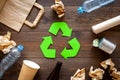 Recycling. Green recycle eco symbol. Recycled arrows sign near matherials for recycle and reuse on dark wooden Royalty Free Stock Photo