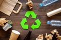 Recycling. Green recycle eco symbol. Recycled arrows sign near matherials for recycle and reuse on dark wooden Royalty Free Stock Photo