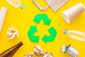 Recycling. Green recycle eco symbol. Recycled arrows sign near matherials for recycle and reuse on yellow background top Royalty Free Stock Photo