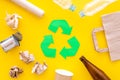 Recycling. Green recycle eco symbol. Recycled arrows sign near matherials for recycle and reuse on yellow background top Royalty Free Stock Photo