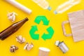 Recycling. Green recycle eco symbol. Recycled arrows sign near matherials for recycle and reuse on yellow background top Royalty Free Stock Photo